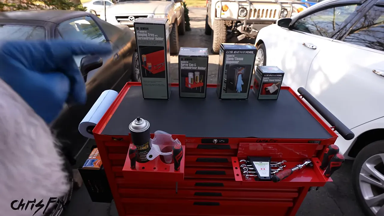 Red tool cart with a paper towel roll, spray can holder, and tool tray mounted on its sides