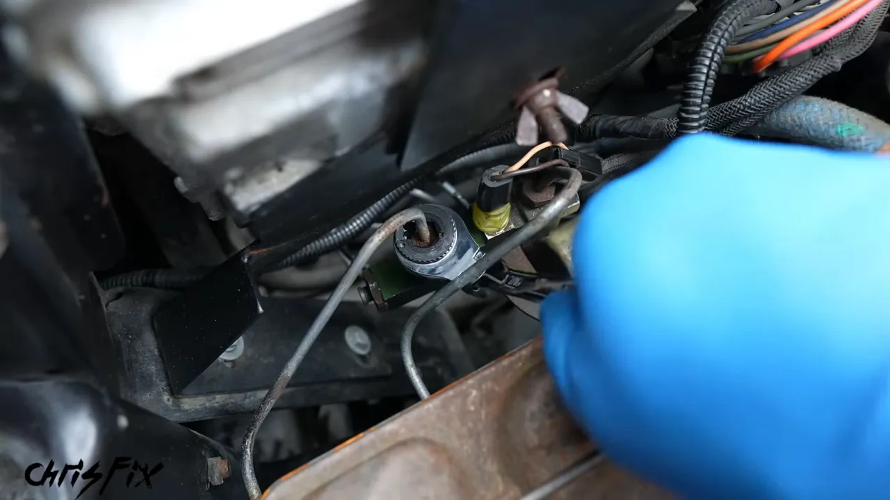 Ratcheting flare nut wrench around a brake line beside the master cylinder
