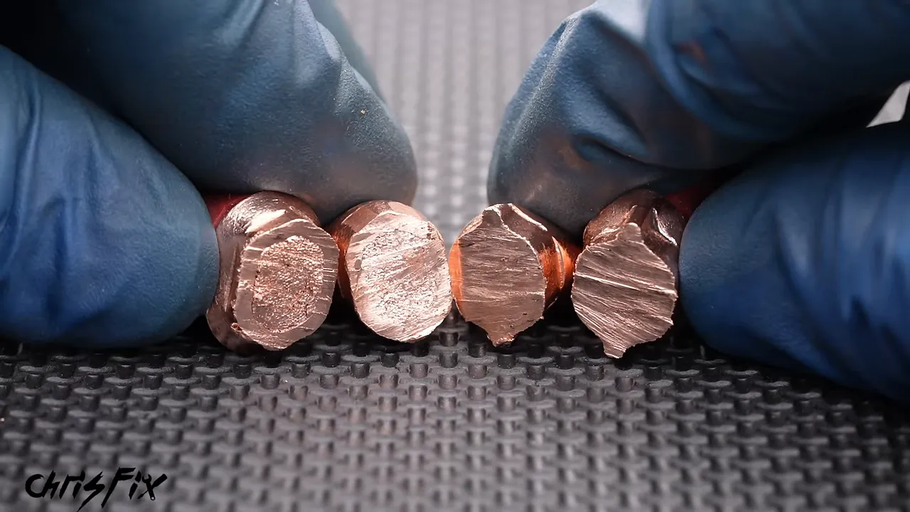 Gloved hands holding cut terminal cross-sections showing different degrees of copper compression
