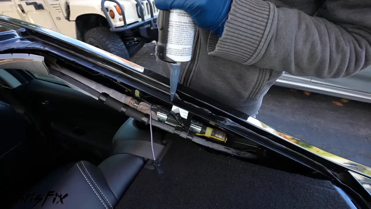 Caulking gun dispensing a raised urethane bead along the rear window opening