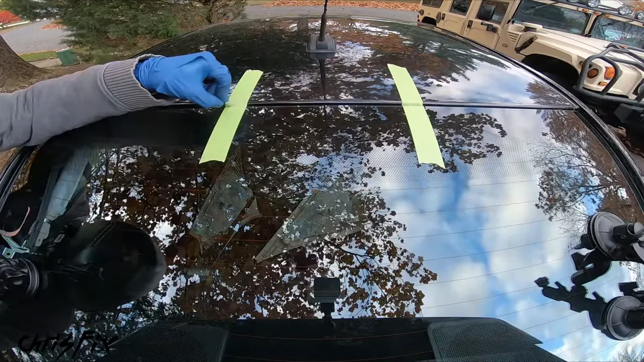 Two strips of green tape spanning the roof and dry-fitted rear glass