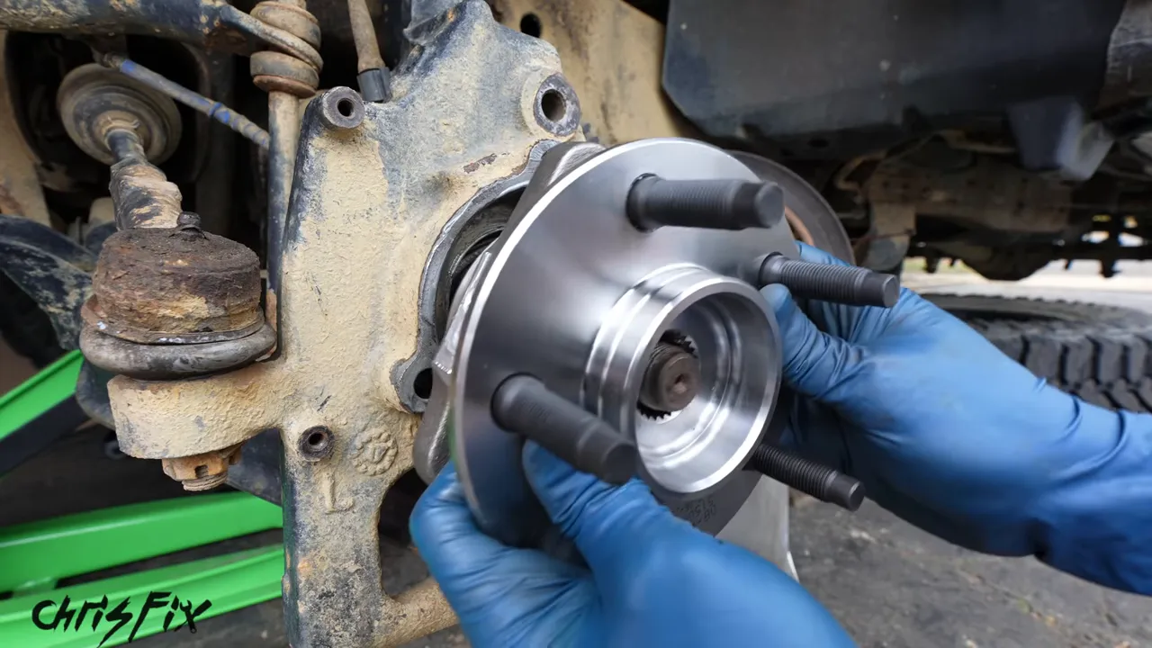 New silver wheel hub aligned with the axle and steering knuckle