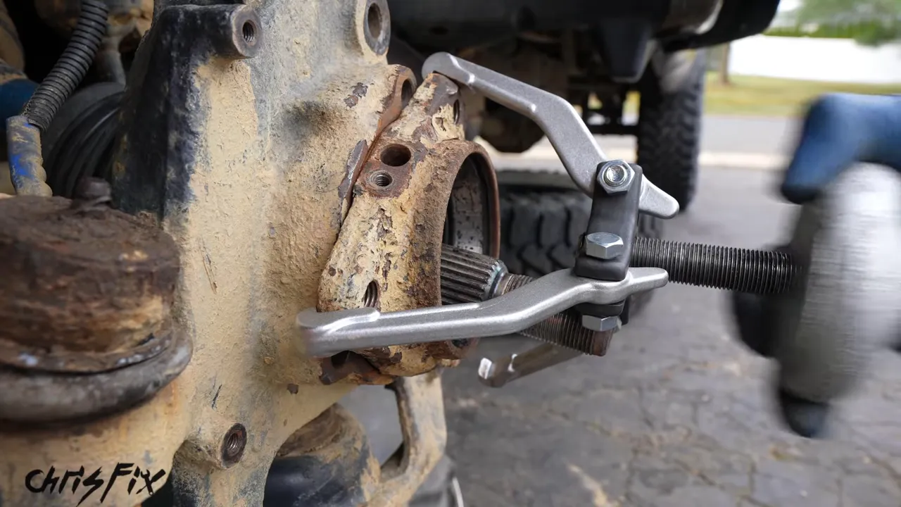 Jaw puller attachment positioned behind the remaining bearing housing in the knuckle