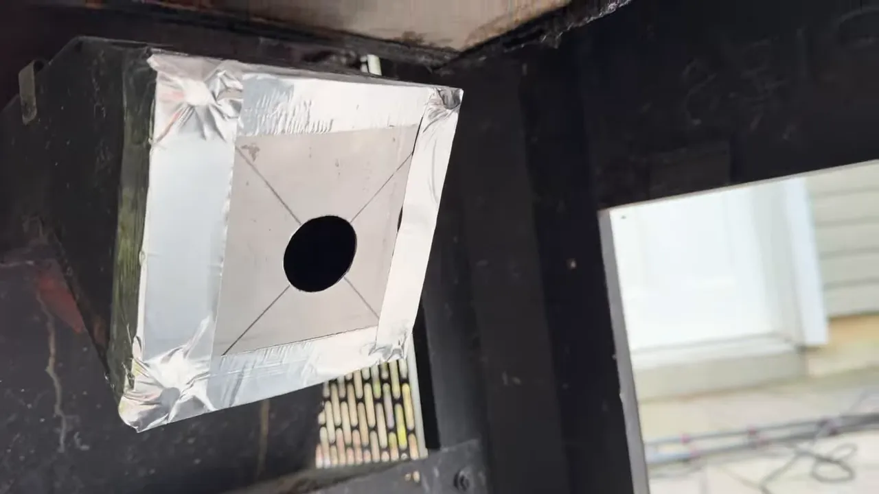 Metal adapter plate with a round center hole and foil tape around its edges