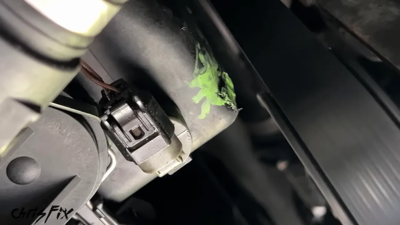 Close-up of the coolant expansion tank beside a black engine pulley