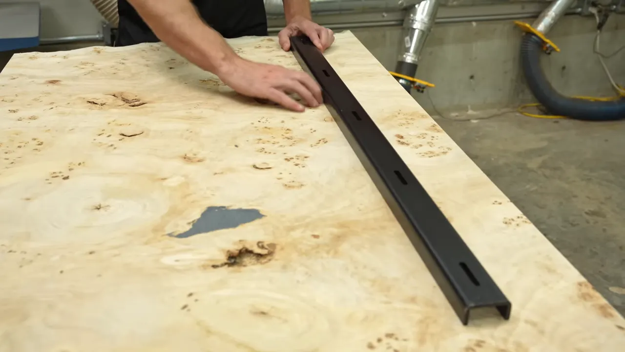 Two long black steel C-channels positioned on a pale burl slab