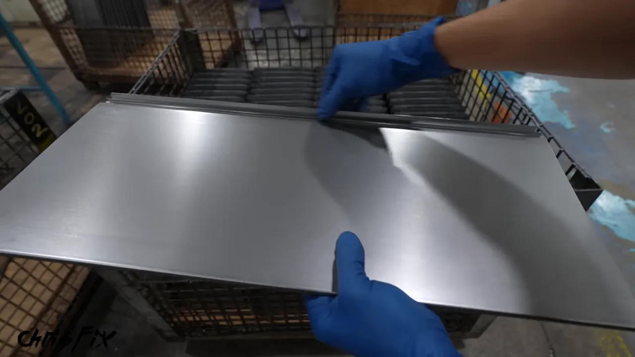 Gloved hands holding an unpainted drawer front with formed upper and lower edges