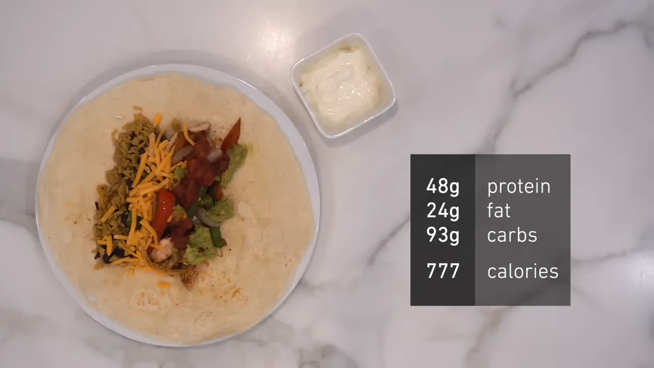 Open tortilla filled with chicken, rice, vegetables, and cheese beside sour cream and meal macros