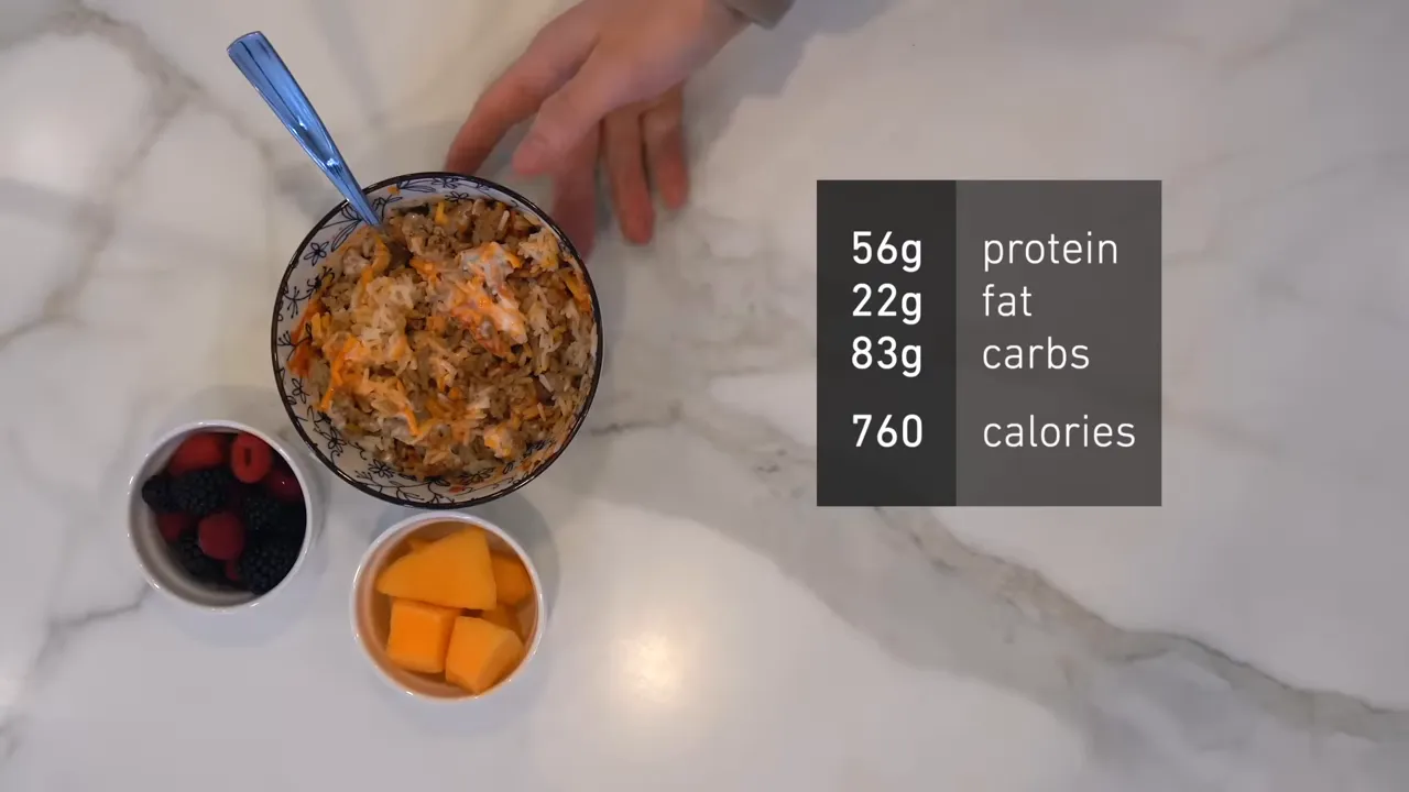 Overhead turkey and rice bowl with berries, cantaloupe, and meal macros