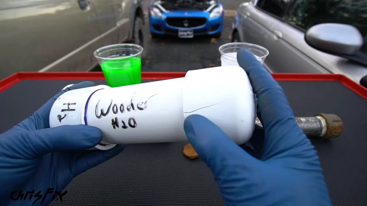 Gloved hands holding a water-filled PVC pipe with a crack near its end cap