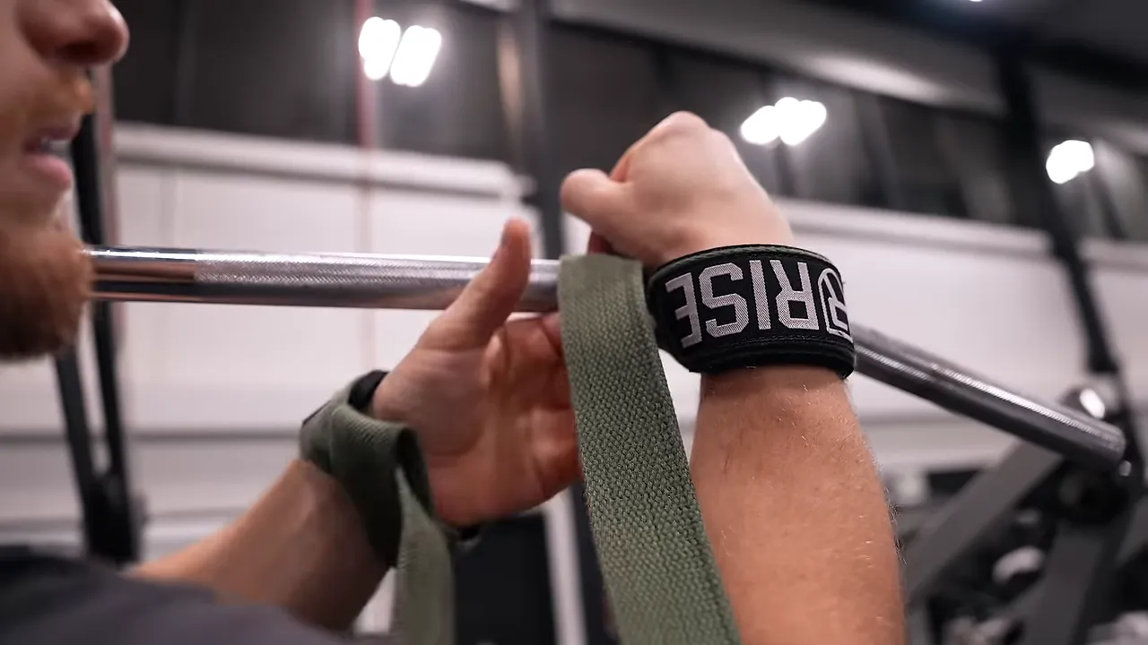 Close-up of lifting straps wrapped around wrists and a pulldown bar
