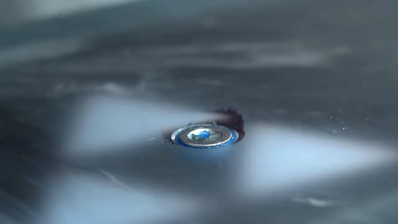 Threaded metal insert seated in the epoxy underside beside a cloth
