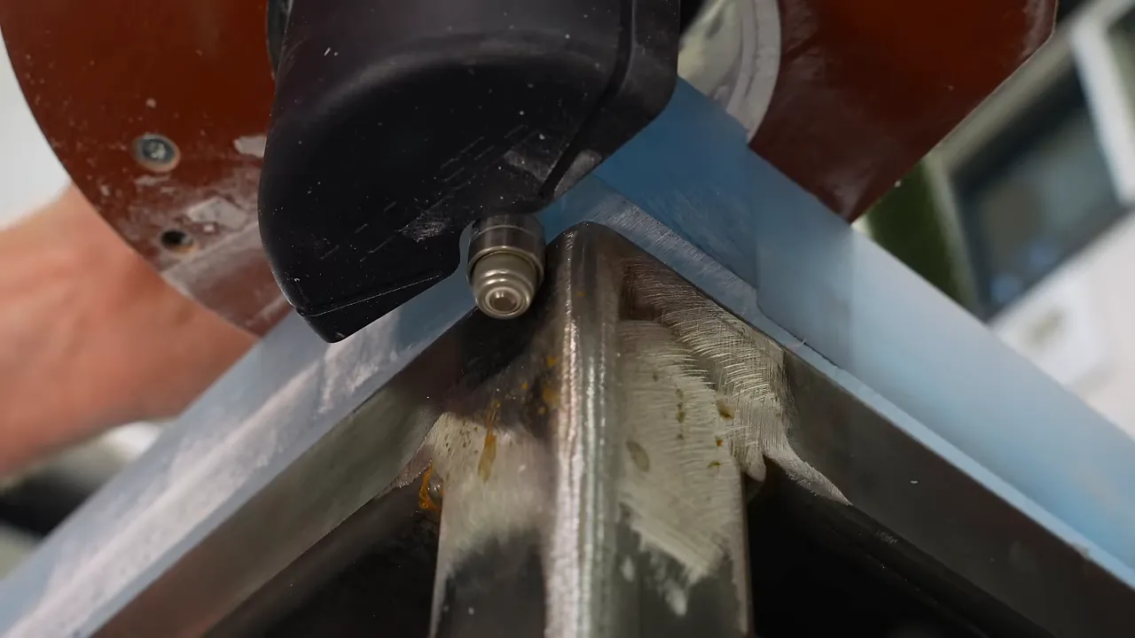 Router bit bearing against the steel frame beneath the blue epoxy table edge