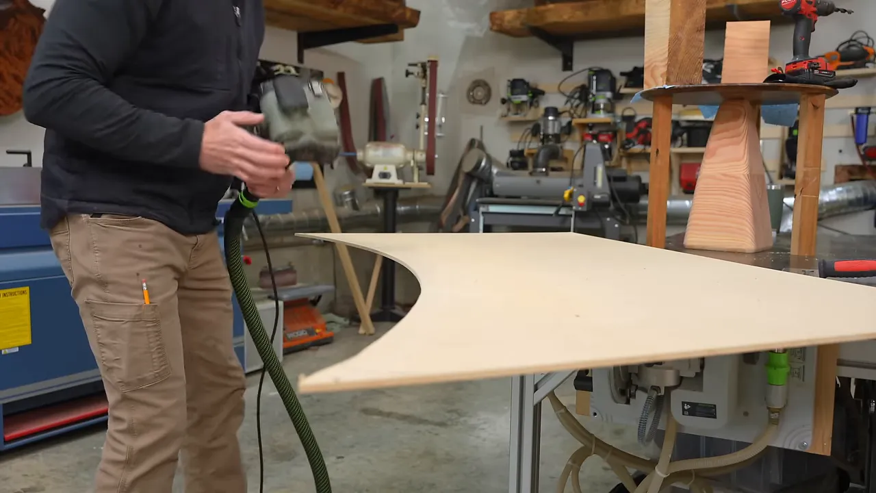 Shaped MDF desk template resting on a workshop bench