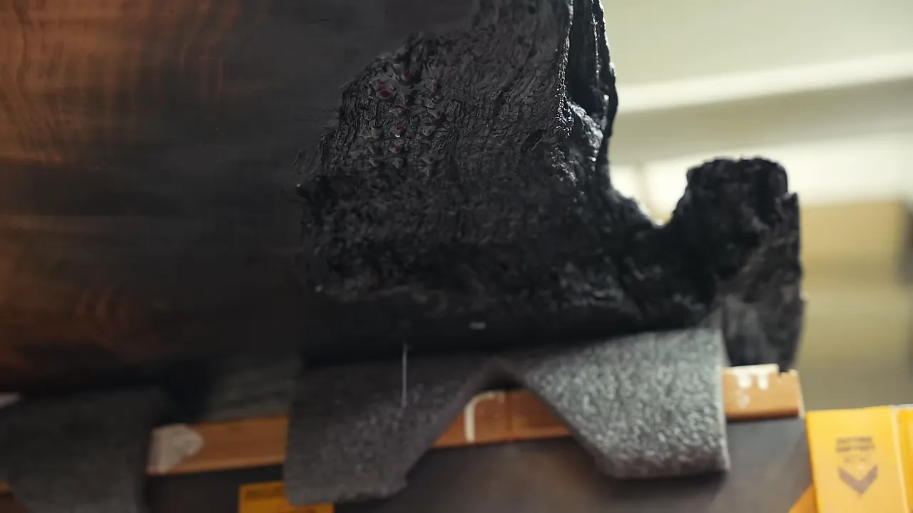 Clear epoxy dripping from a charred opening on the underside of the slab