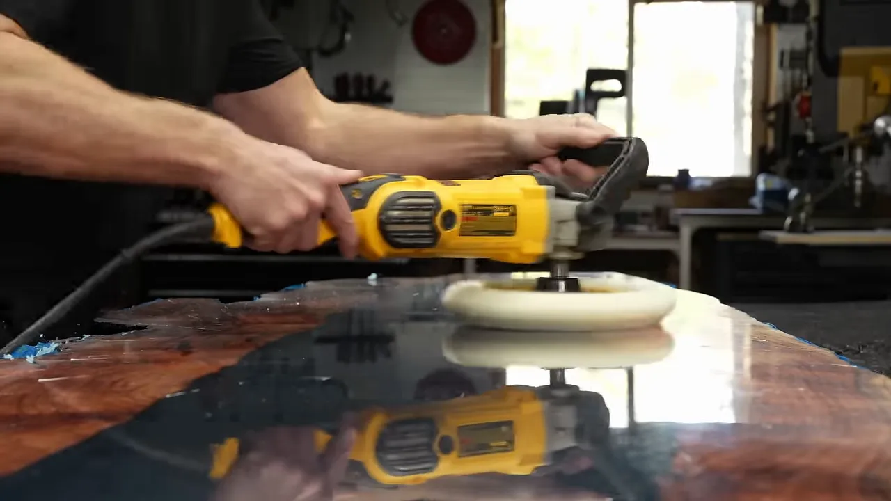 Buffer polishing a reflective tabletop with redwood bordering a dark center