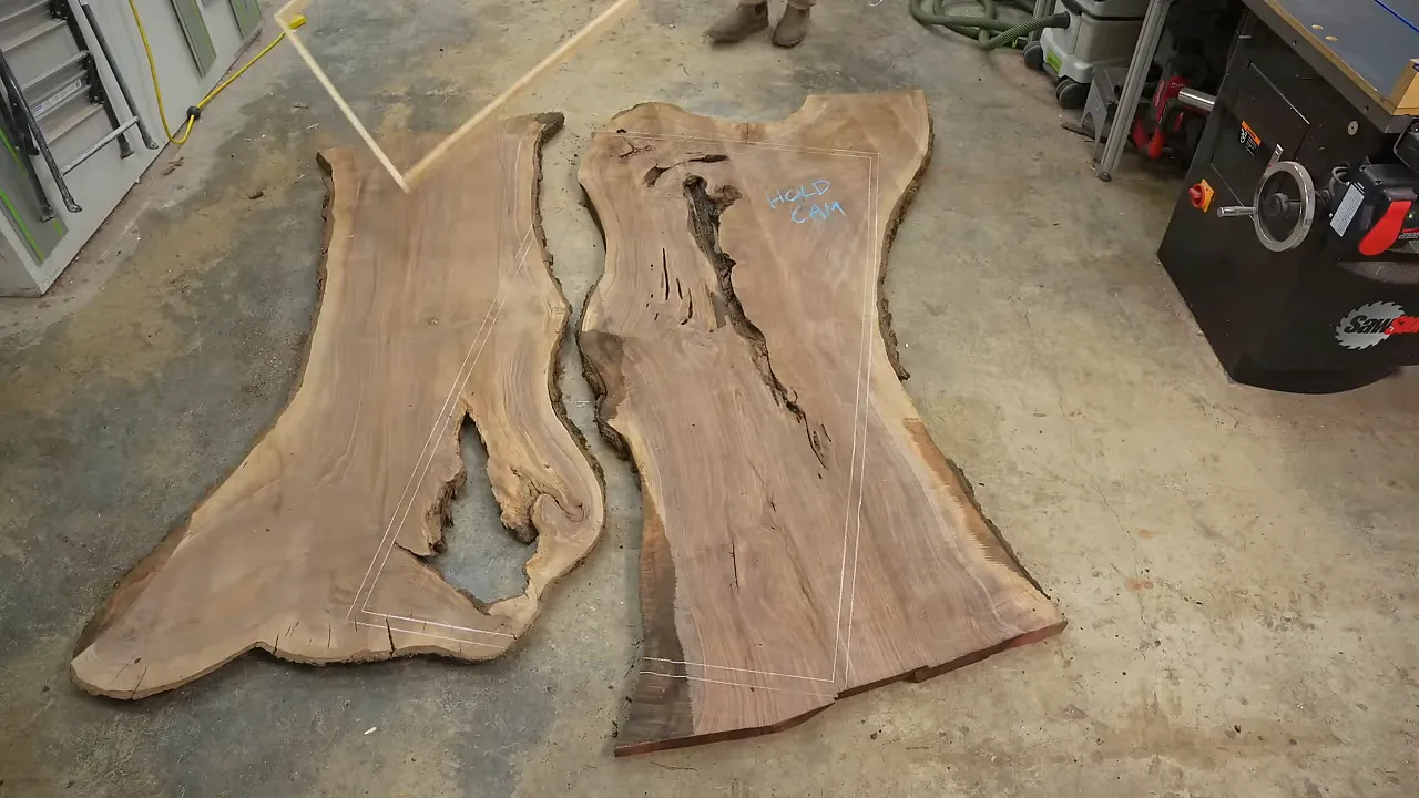Walnut slabs arranged on a shop floor inside a rectangular layout frame