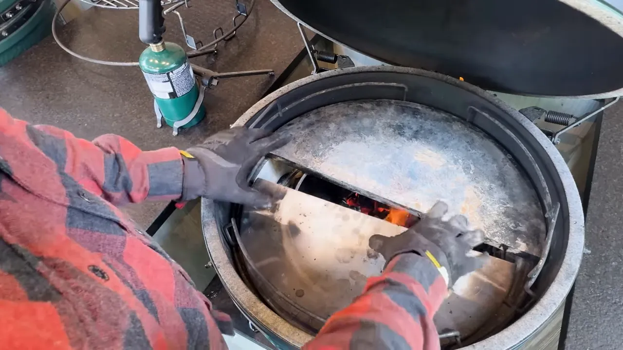 Two half-moon surfaces inside an open Big Green Egg with a gap between them