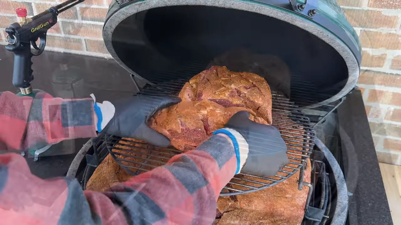 Seasoned beef roasts arranged on two cooking levels inside a Big Green Egg