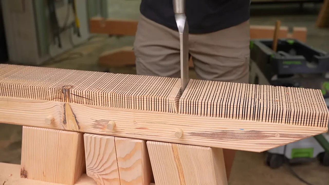 Top beam of the assembled timber base covered in closely spaced saw kerfs