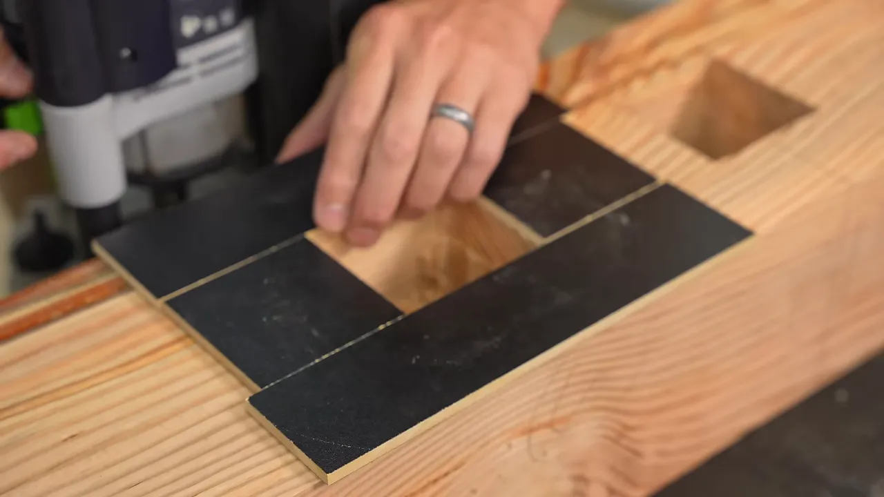 Black template guides positioned around a mortise in a large timber