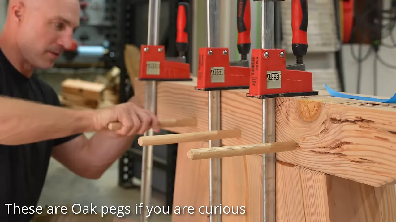 Clamped timber base assembly with long wooden pegs projecting from its face