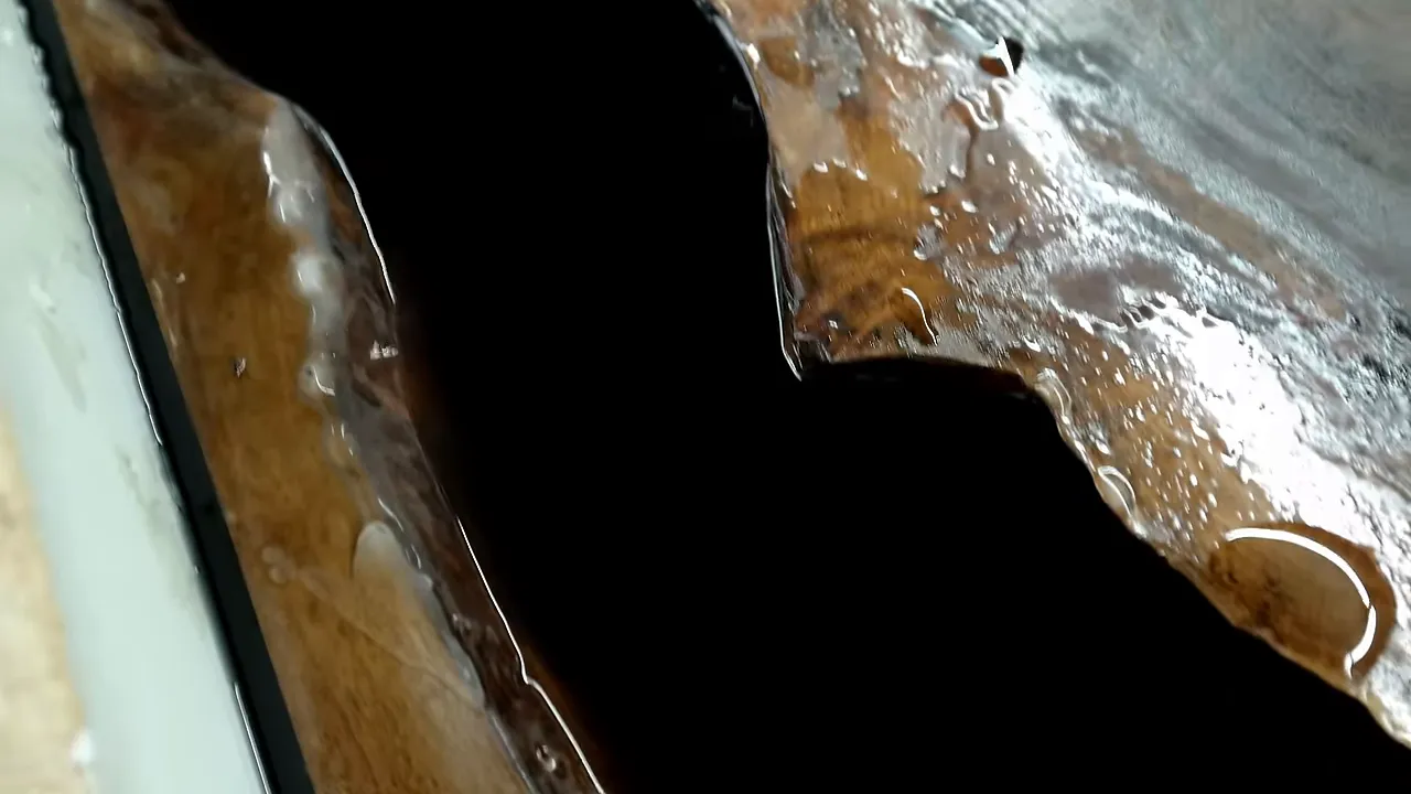 Pale cloudy patches along a walnut live edge beside glossy black epoxy