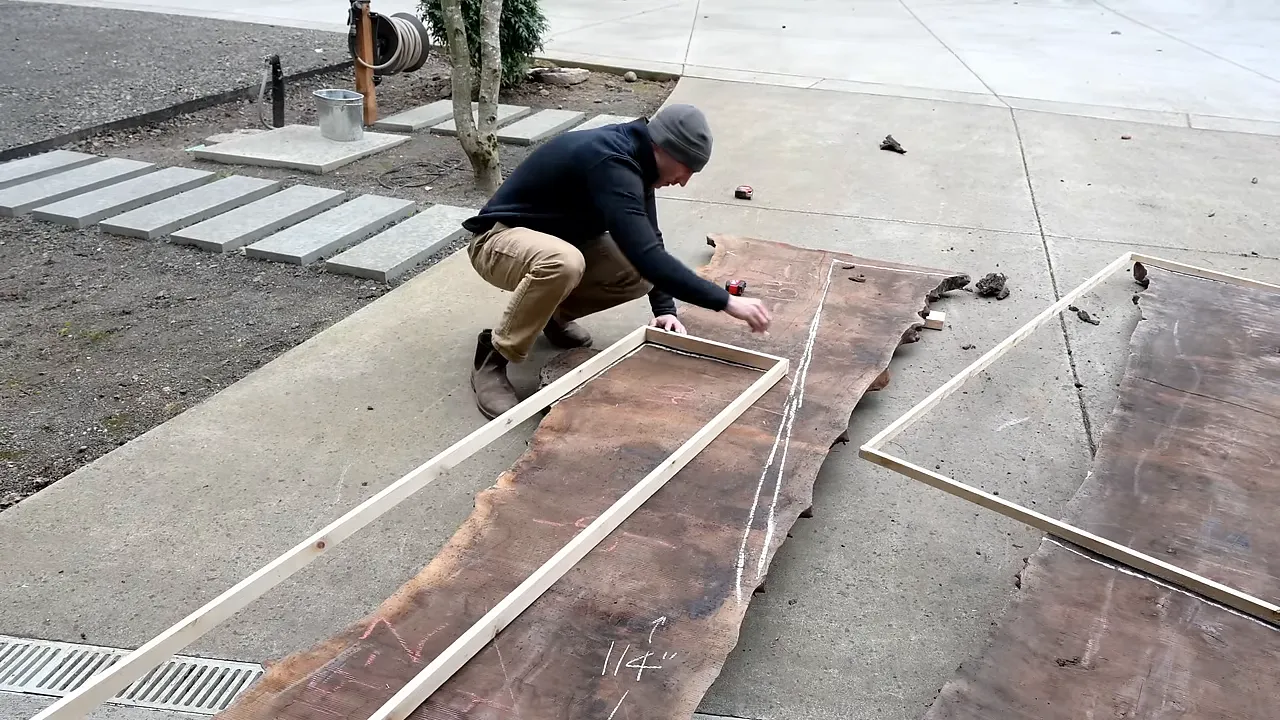 Rectangular layout templates positioned over walnut slabs on a driveway