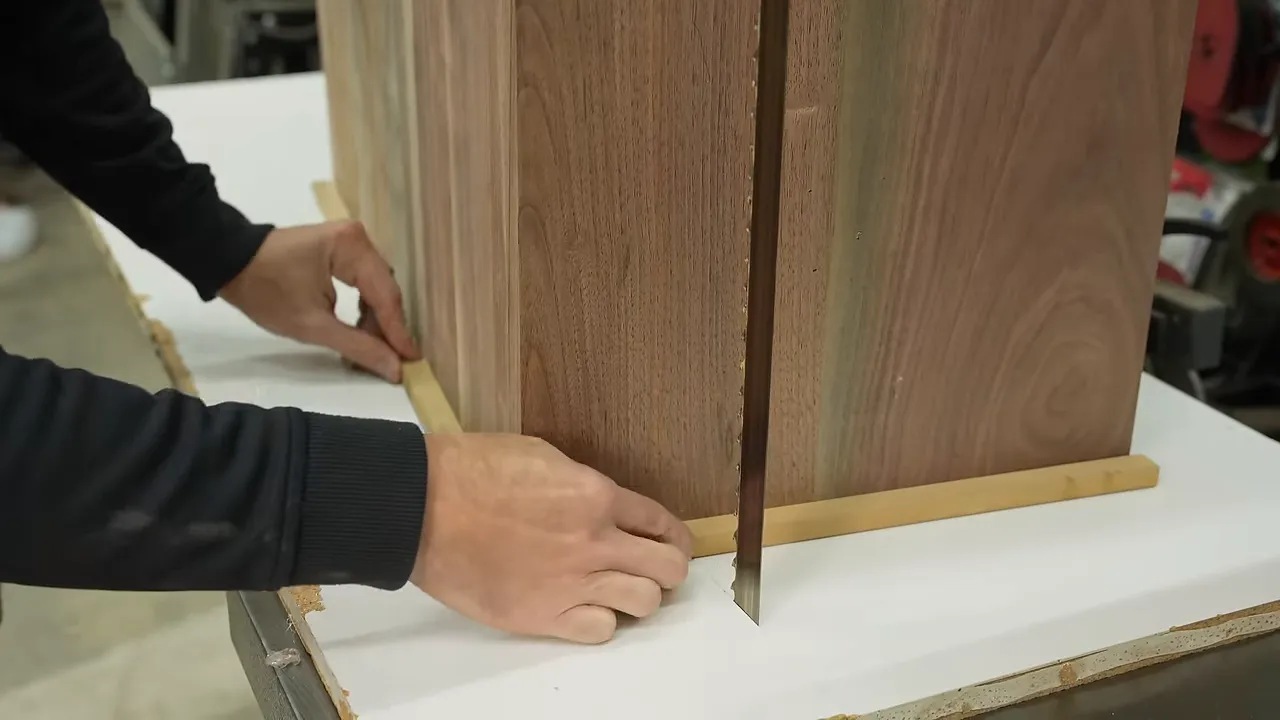 Walnut block positioned on a white bandsaw sled with small wooden stops
