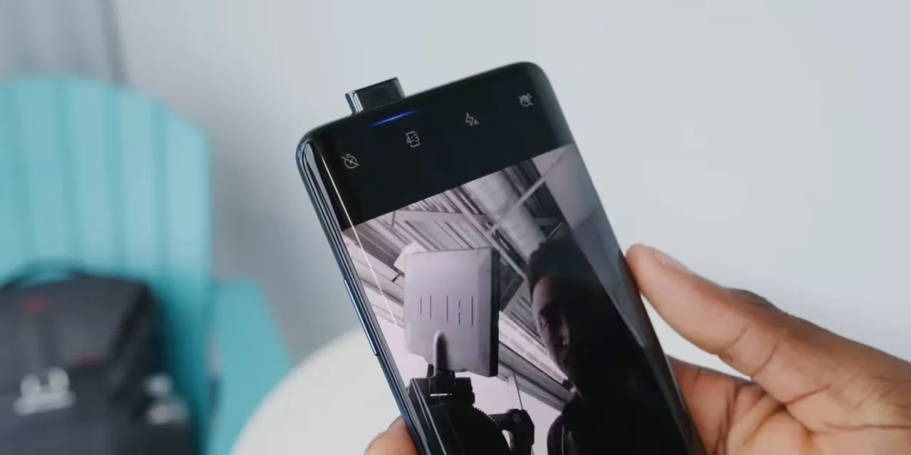 OnePlus phone with its pop-up selfie camera extended and the camera app open