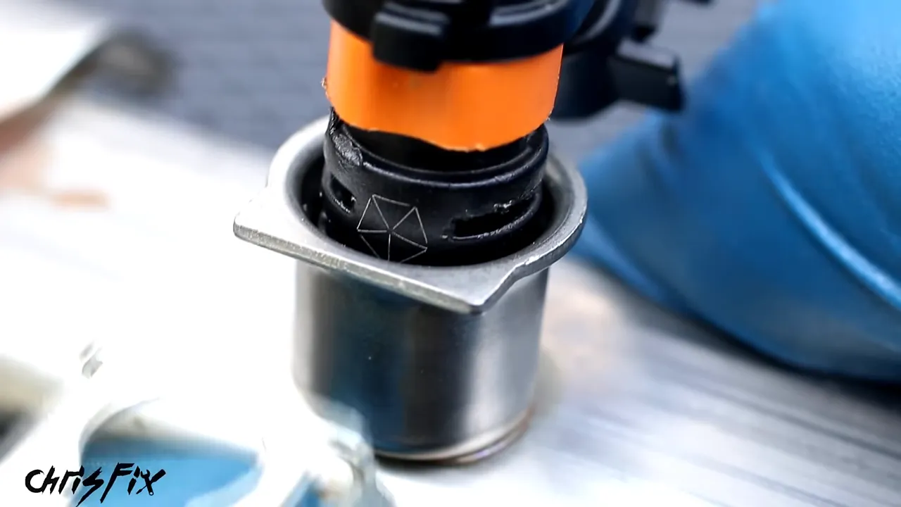 Close-up of an injector retaining clip engaged beneath the fuel rail socket