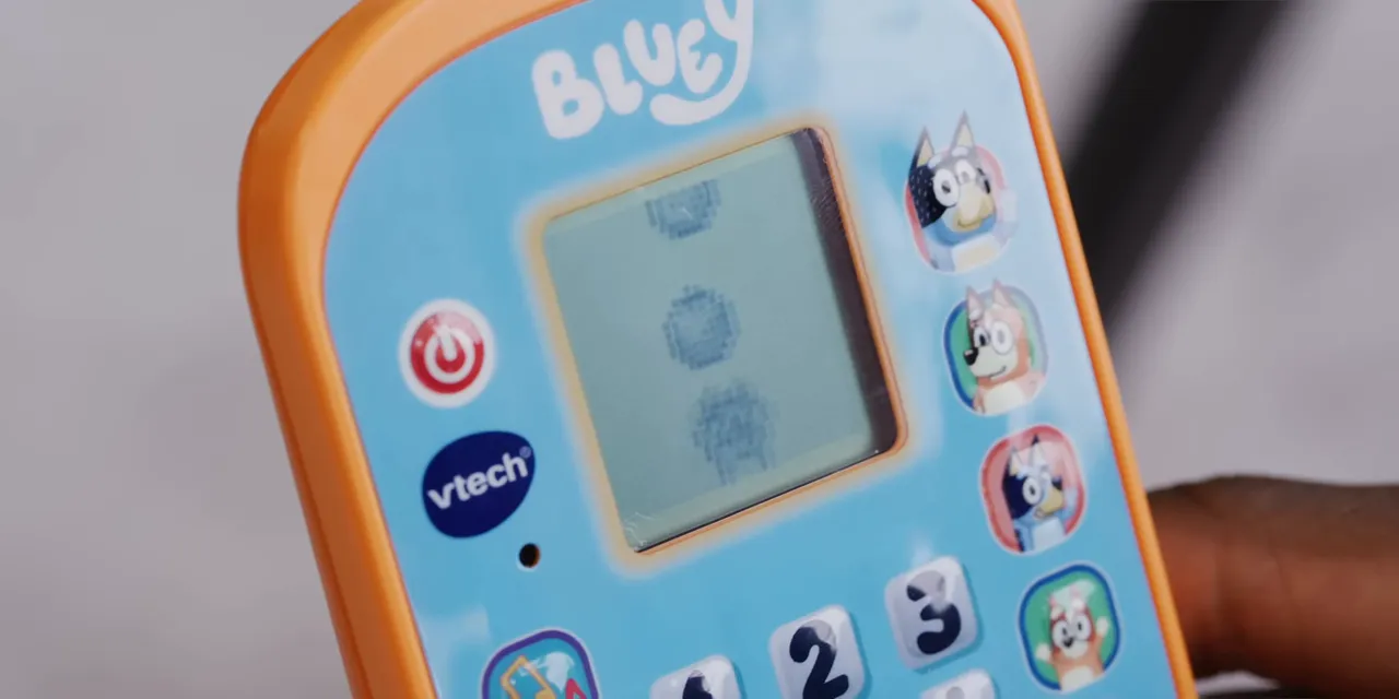Close-up of the Bluey phone display showing pixelated bubbles above a character