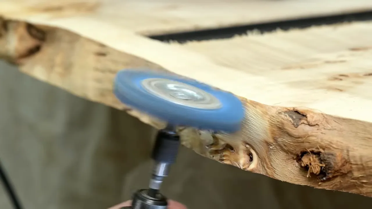 Blue nylon abrasive wheel beneath a burl edge with small rounded projections
