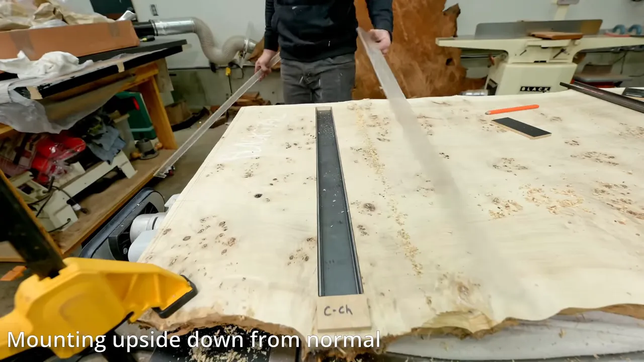 Steel channel seated in a routed recess across the underside of the pale burl slab