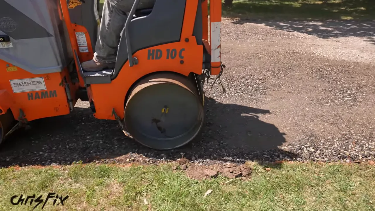 Tandem roller compacting the stone base along the lawn edge