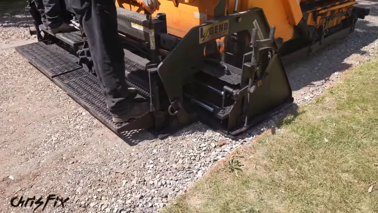 Rear screed of an asphalt paver smoothing the driveway stone base