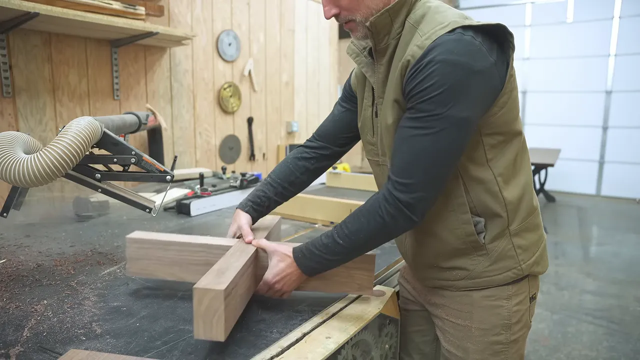 Two walnut base assemblies joined in a cross on a workbench