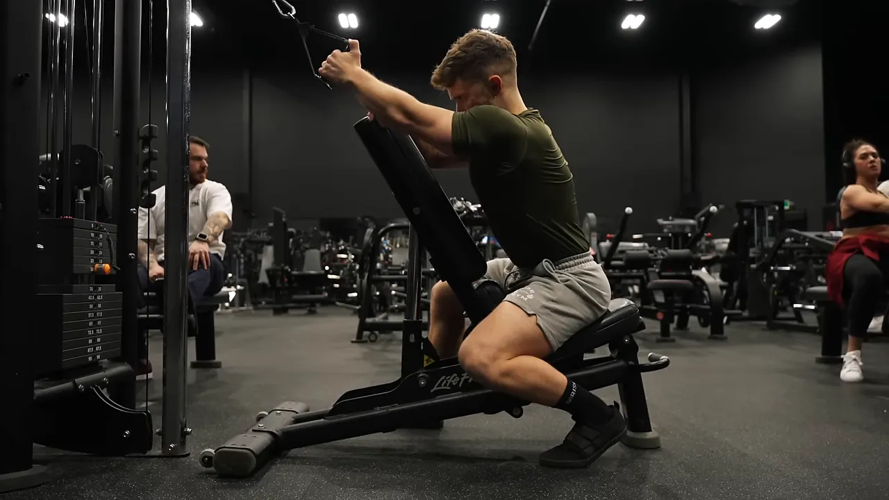 One-arm cable pulldown performed while bracing against an incline bench
