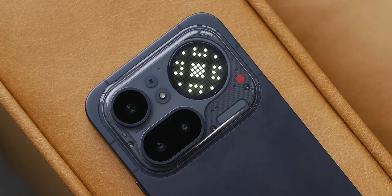 Nothing Phone 4A Pro on a tan chair with a notification symbol illuminated on its circular Glyph Matrix