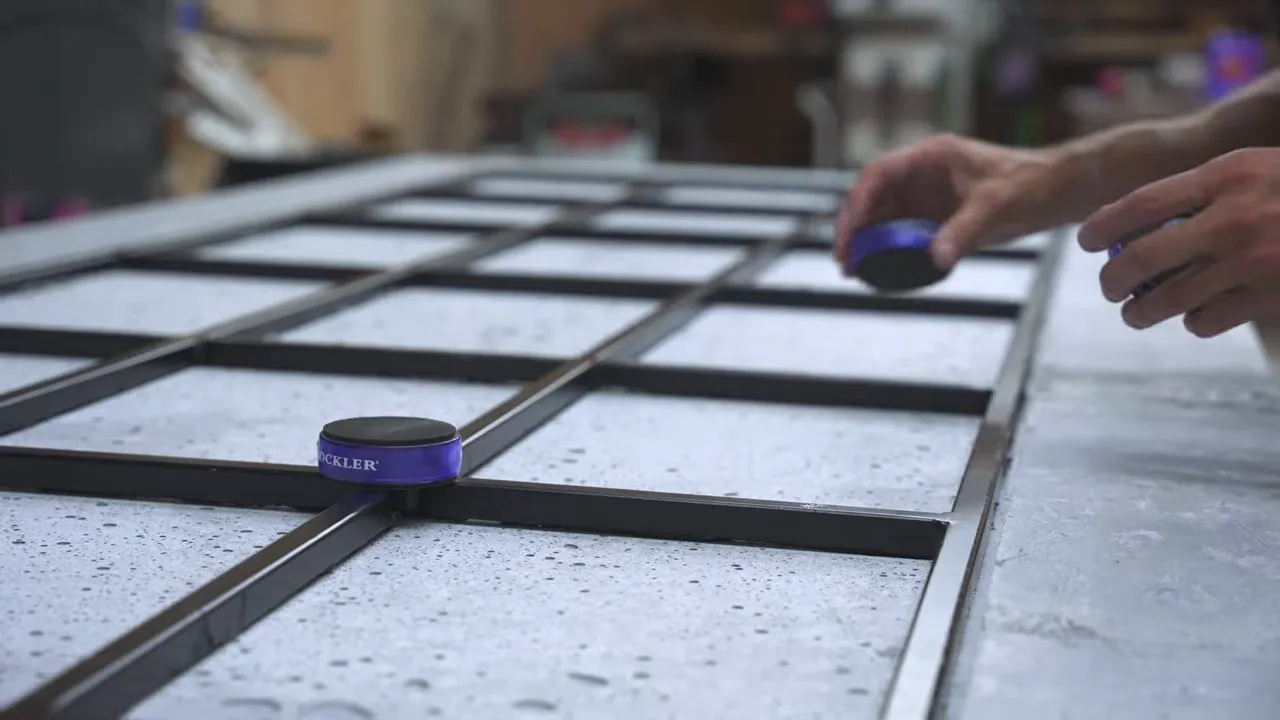 Black steel support grid fitted into the recessed underside of the concrete tabletop