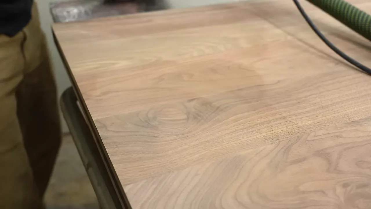 Curved walnut patch fitted flush into the surrounding grain of the door panel