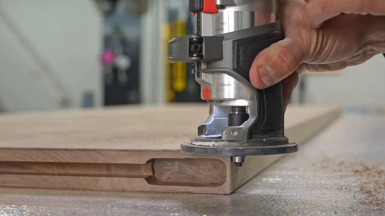 Router refining a recessed grip along the walnut door edge