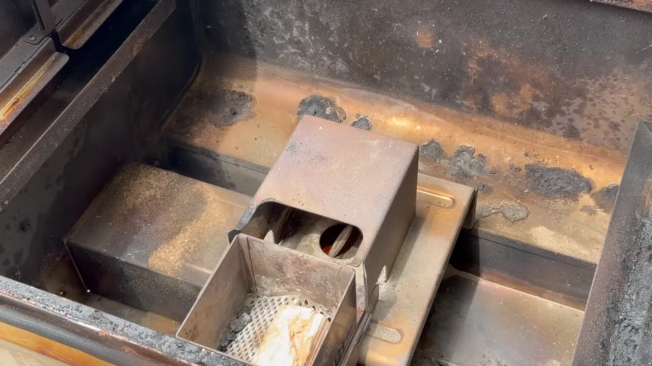 Wood chunk sitting in the exposed Camp Chef smoke box above the fire pot