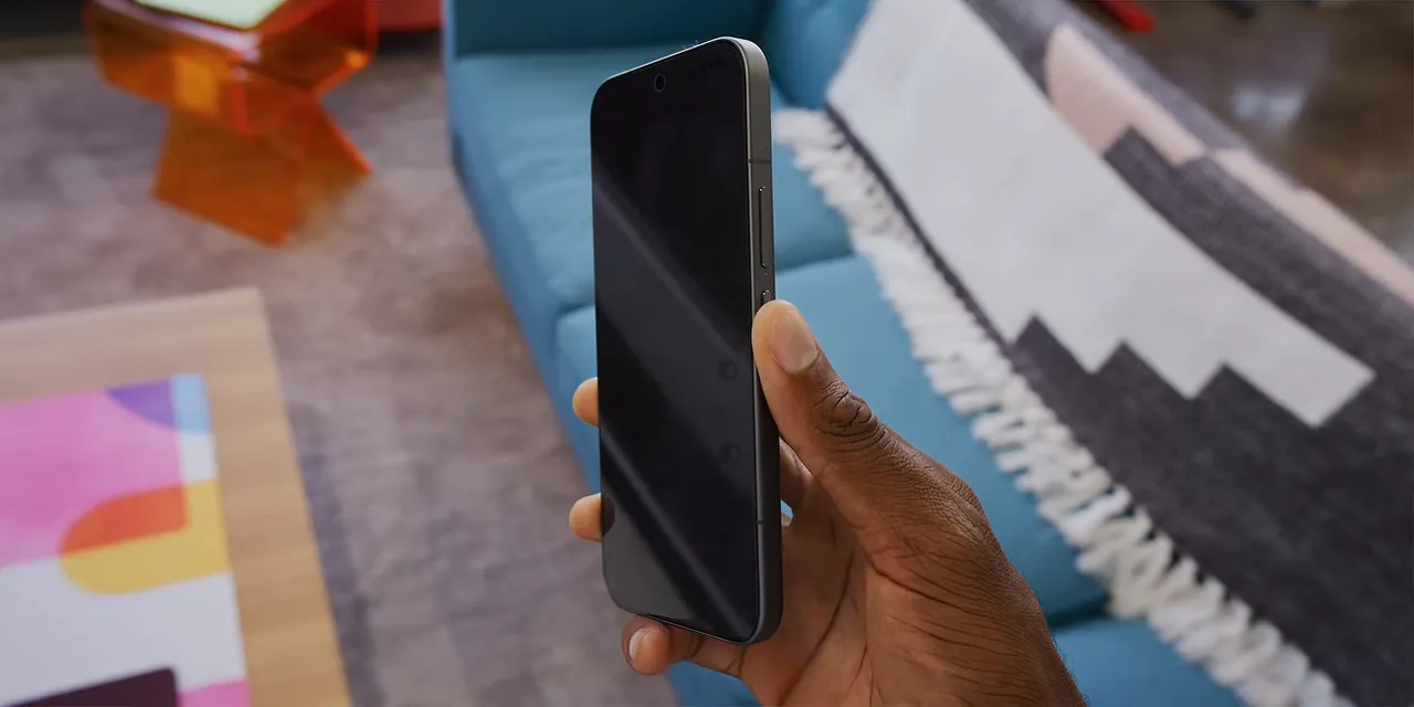 Phone held at an angle with its privacy settings screen appearing dark