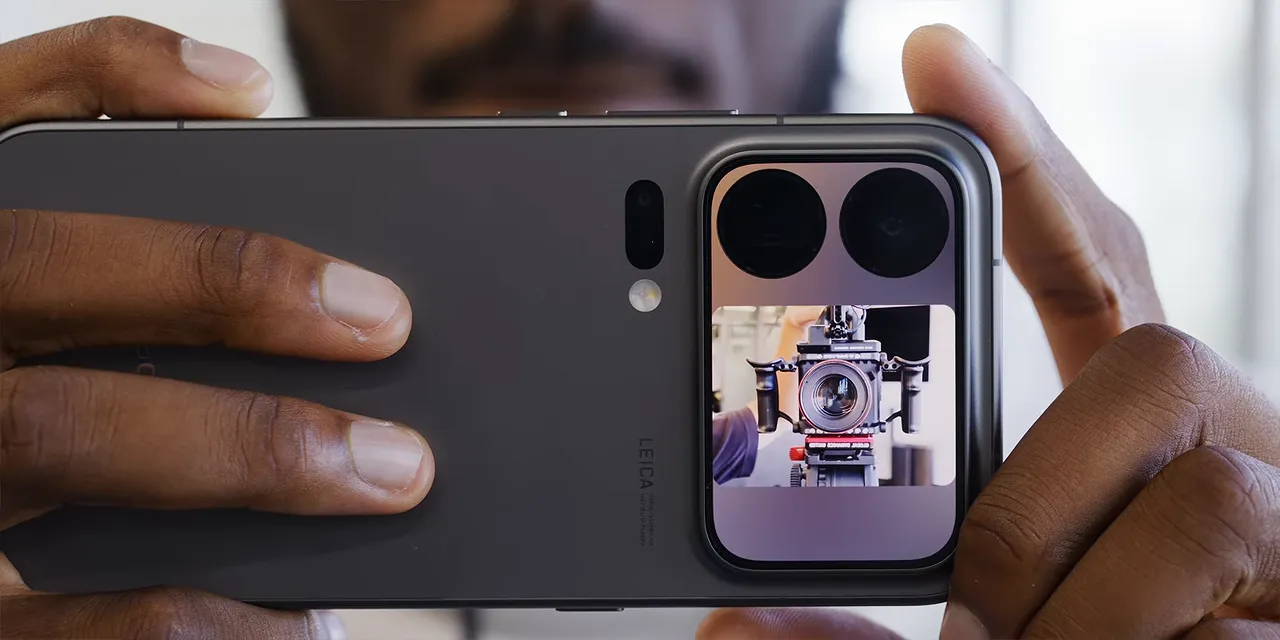 Phone held horizontally with its rear display showing a live camera preview