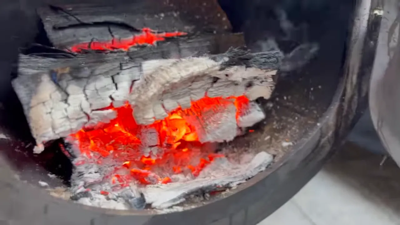 Glowing embers and partially burned wood inside an open firebox