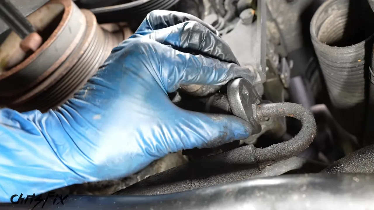 Flare nut crow’s-foot wrench seated around the power steering pump line fitting