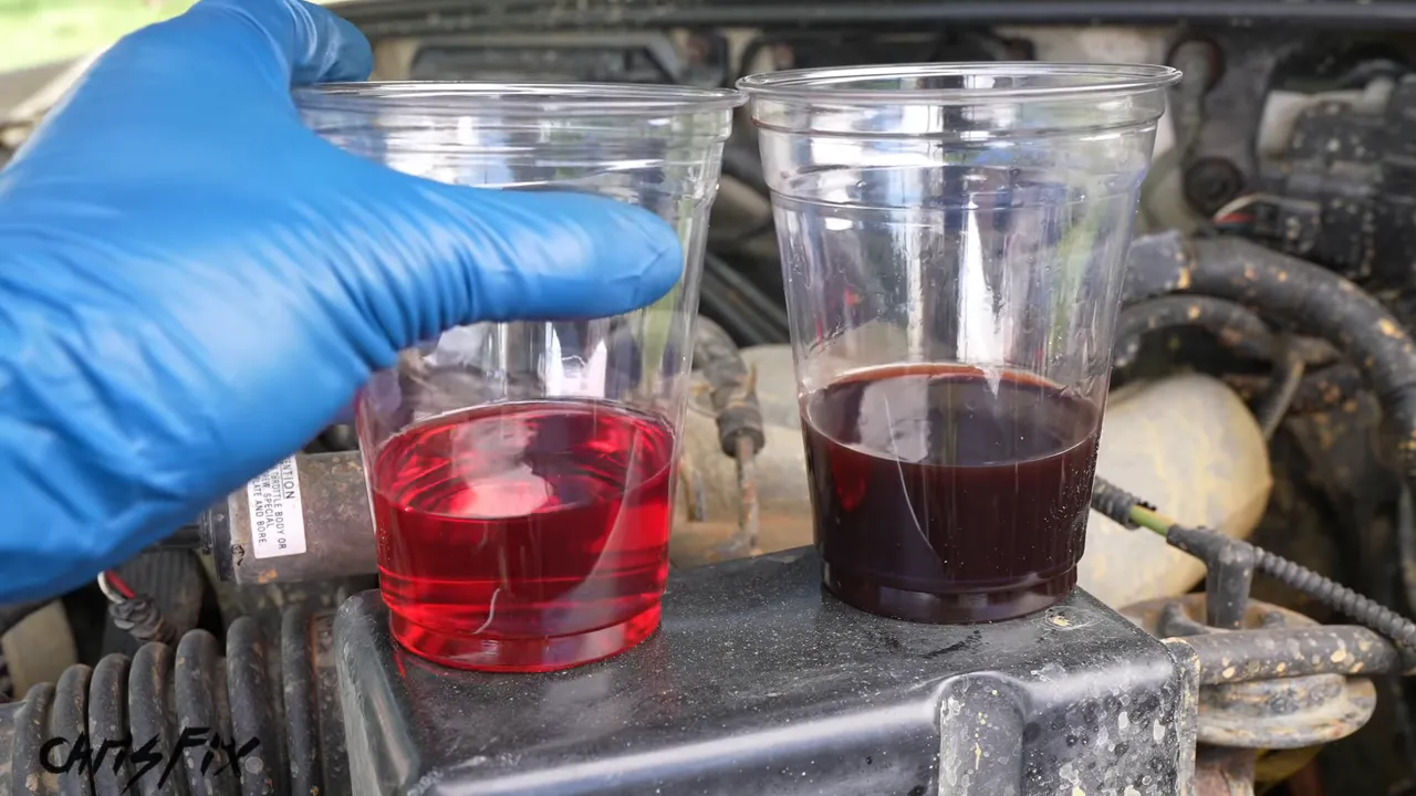 Two clear cups containing bright red fluid on the left and dark fluid on the right