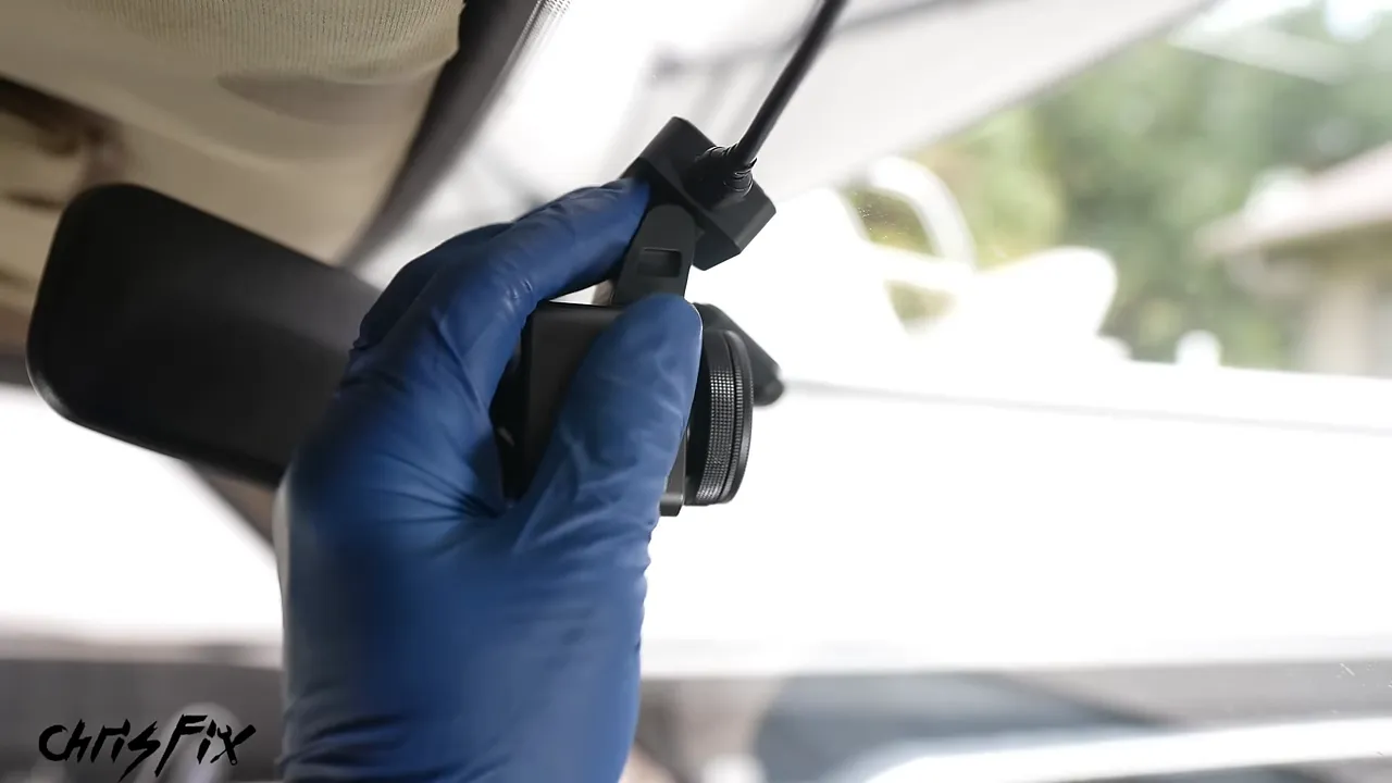 Dash camera mounted high on the windshield beside the rearview mirror
