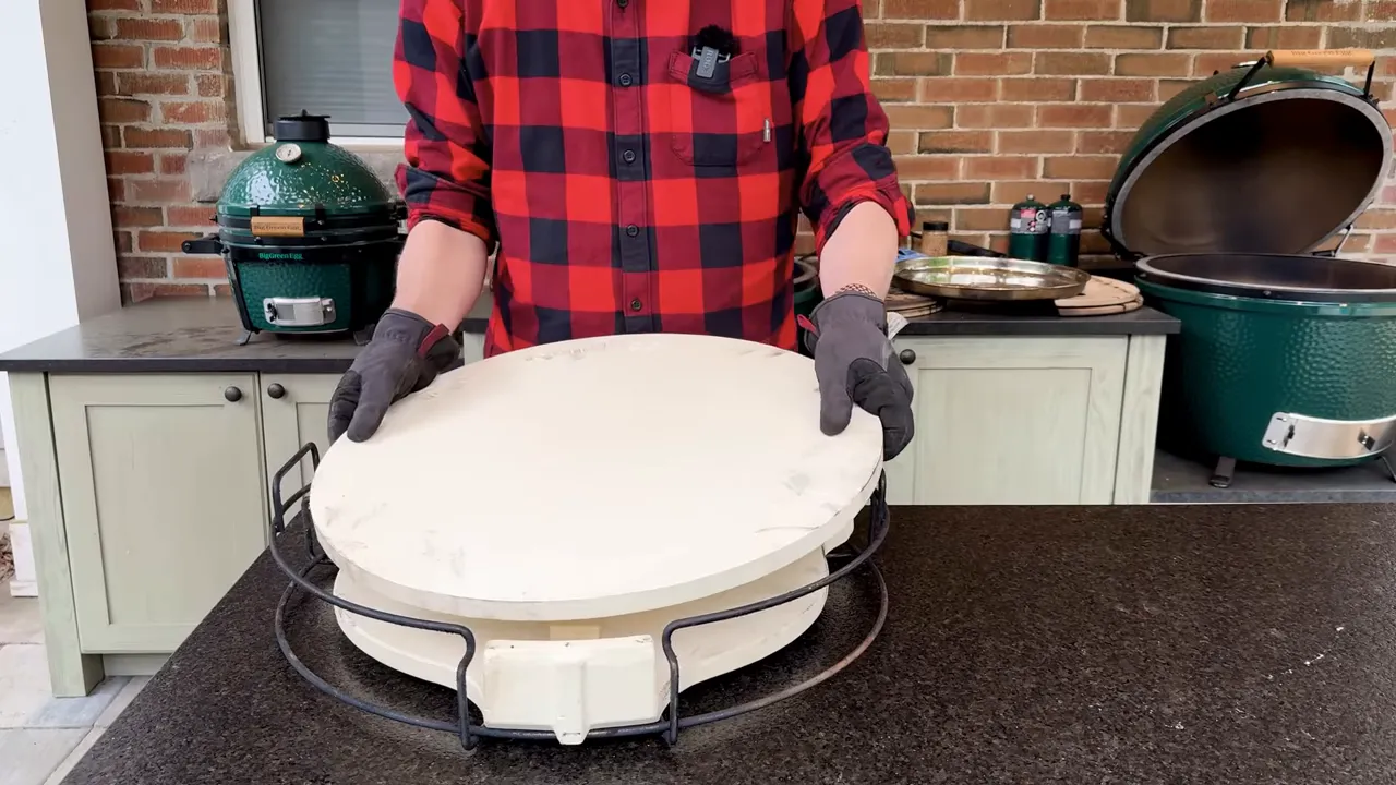 Pizza stone stacked above a convEGGtor on a metal support rack